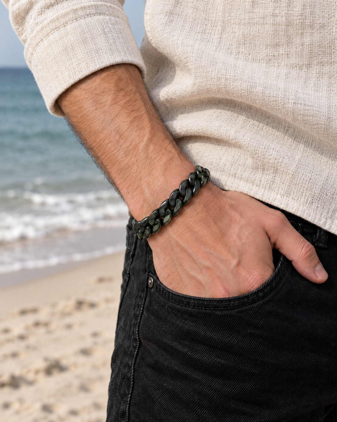 Classic Cuban Link Chain Bracelet in Dark Green Nephrite, worn with a hand in a pocket at the beach.