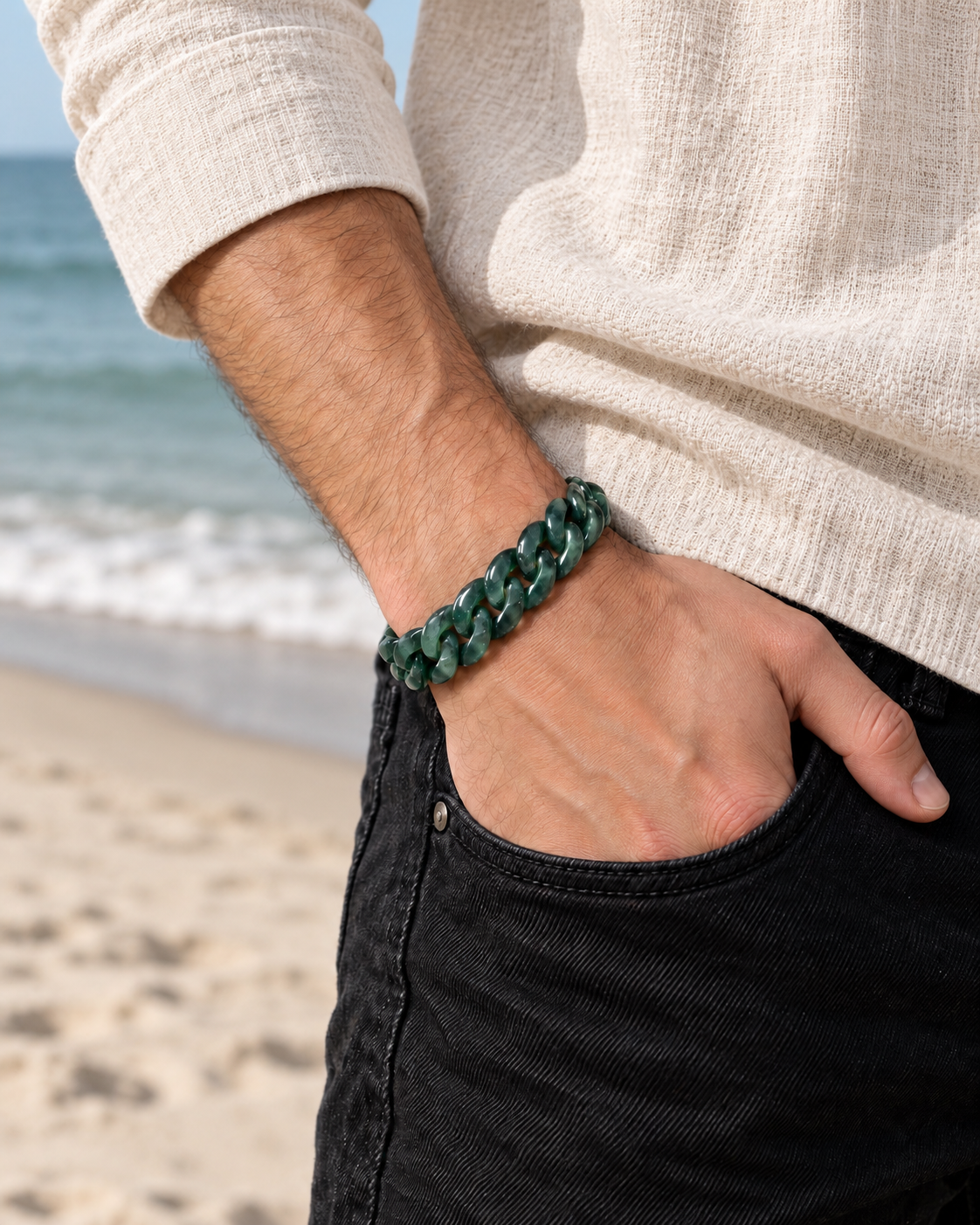 Classic Cuban Link Chain Bracelet in Jelly Green Mayan Jade, worn with a hand in a pocket at the beach.