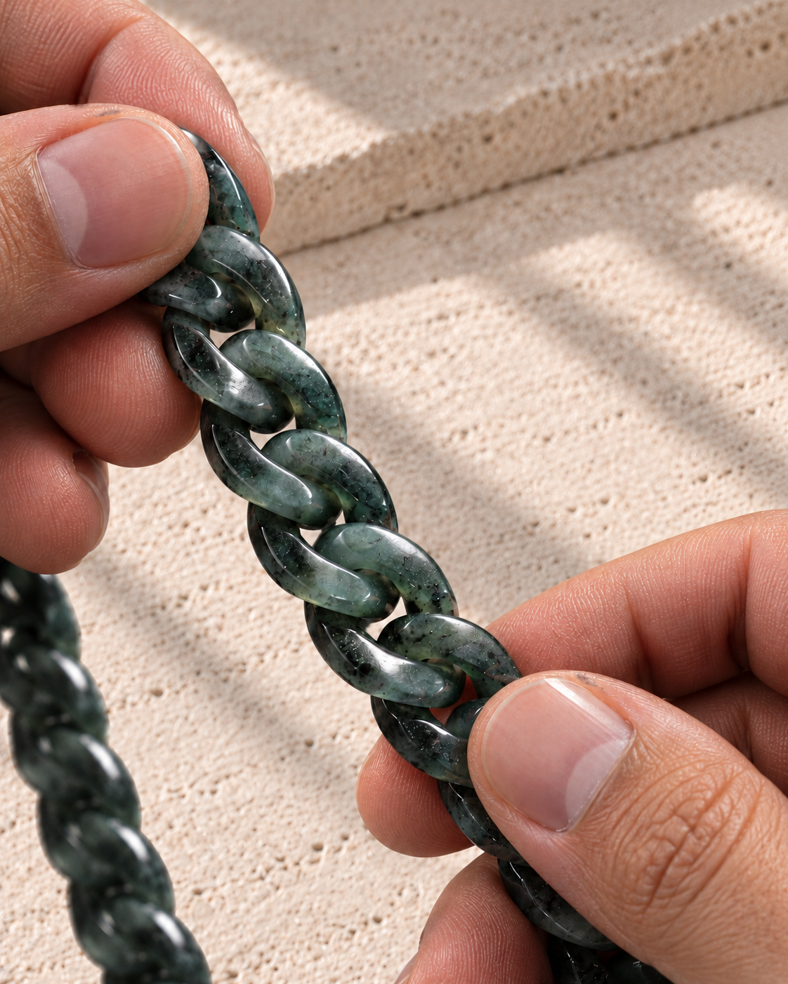 Classic Cuban Link Chain Necklace in Black Jade, held between bare fingers, showing the carved links.