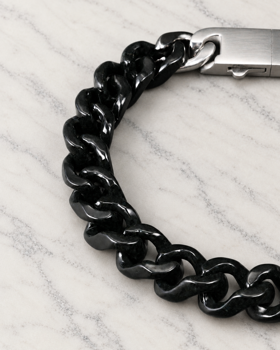 Single Piece Carved Cuban Chain Bracelet in Black Jade, material and construction close-up on ivory marble.