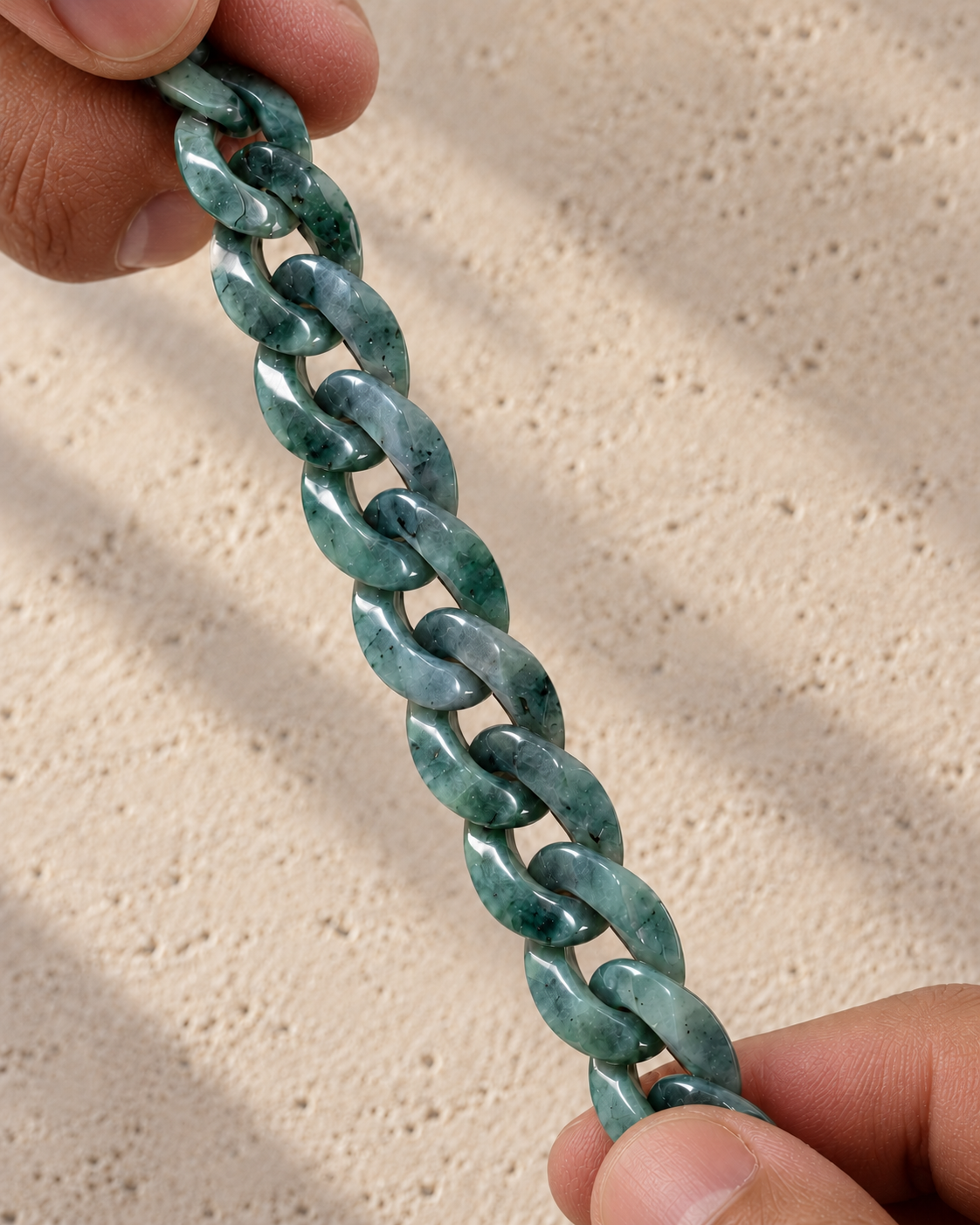 Classic Cuban Link Chain Necklace in Black Jade, held between bare fingers, showing the carved links.