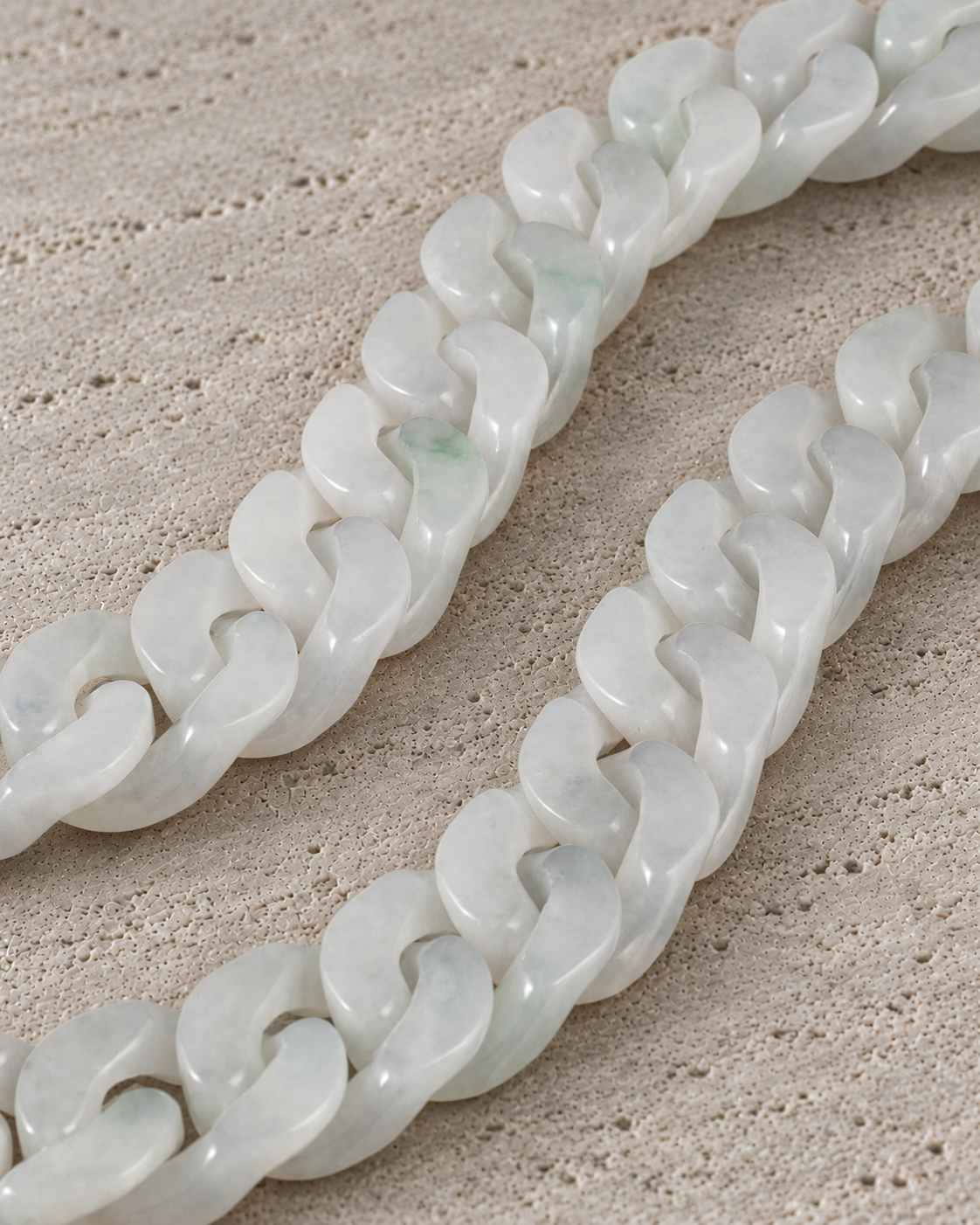 Classic Cuban Link Chain Bracelet in White Jade, material and construction close-up on warm grey stone.