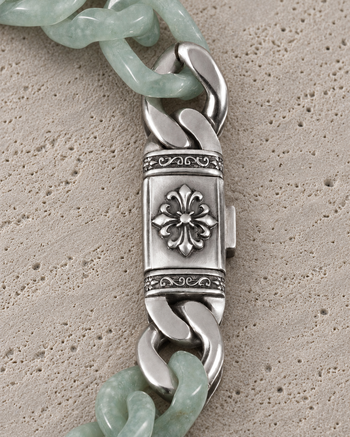 Silver Relic clasp with light green jade links, close-up on matte grey stone.