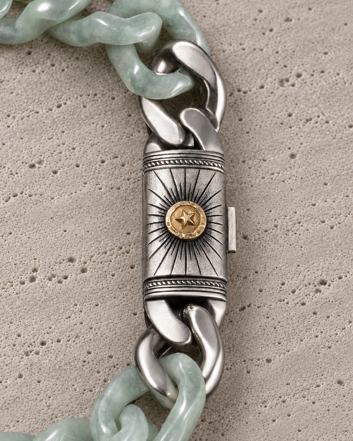 Silver Sol clasp with light green jade links, close-up on matte grey stone.