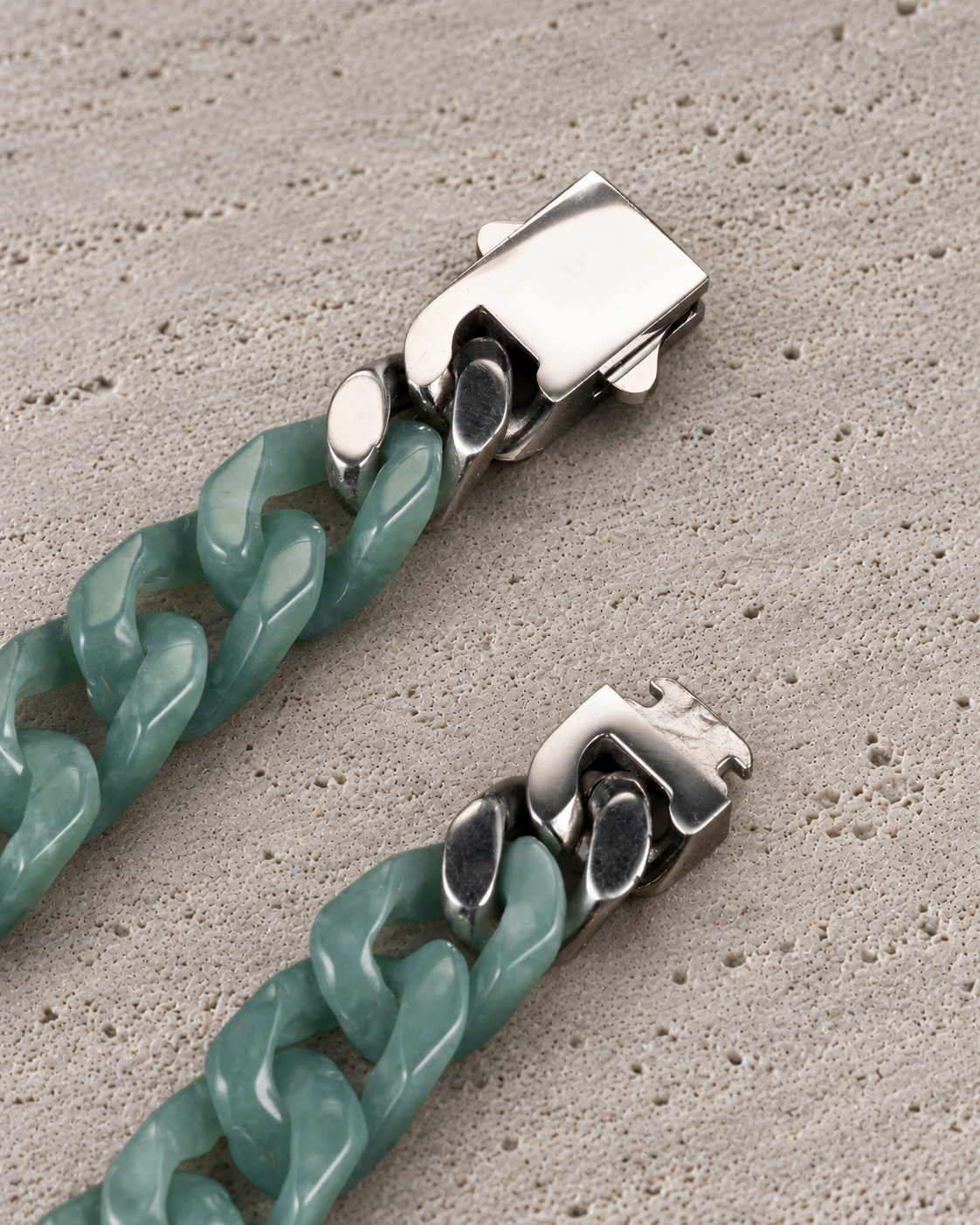 Single Piece Carved Cuban Chain Bracelet in Green Jade, clasp close-up on matte grey stone.