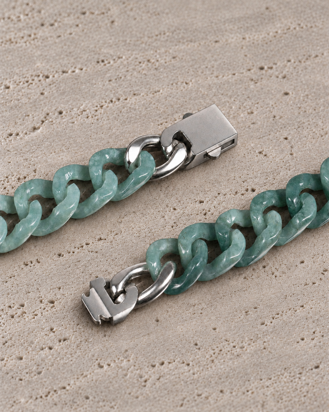 Single Piece Carved Cuban Chain Bracelet in Green Jade, clasp close-up on matte grey stone.