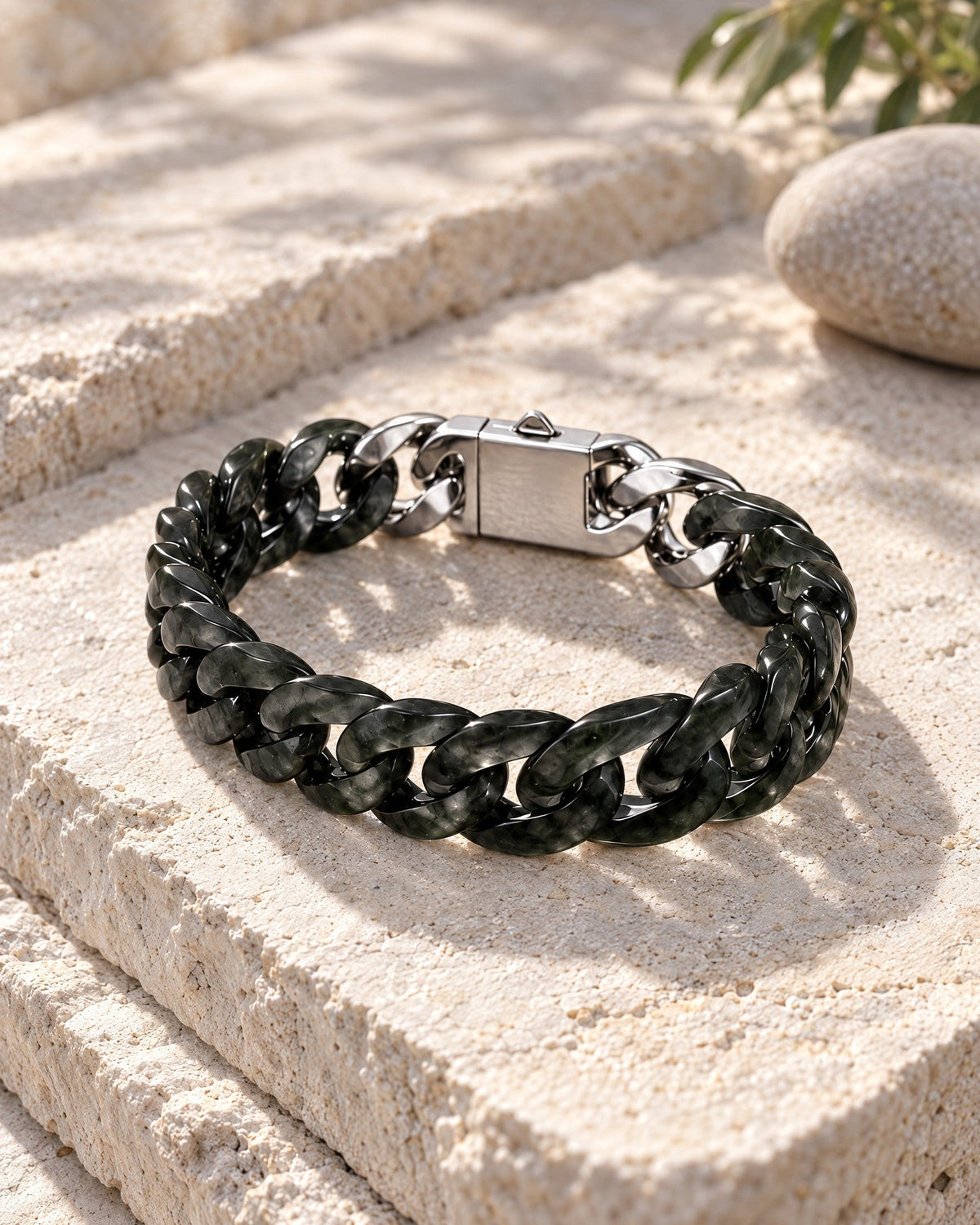 Classic Cuban Link Chain Bracelet In Dark Green Nephrite resting on its side on pale stone in soft daylight