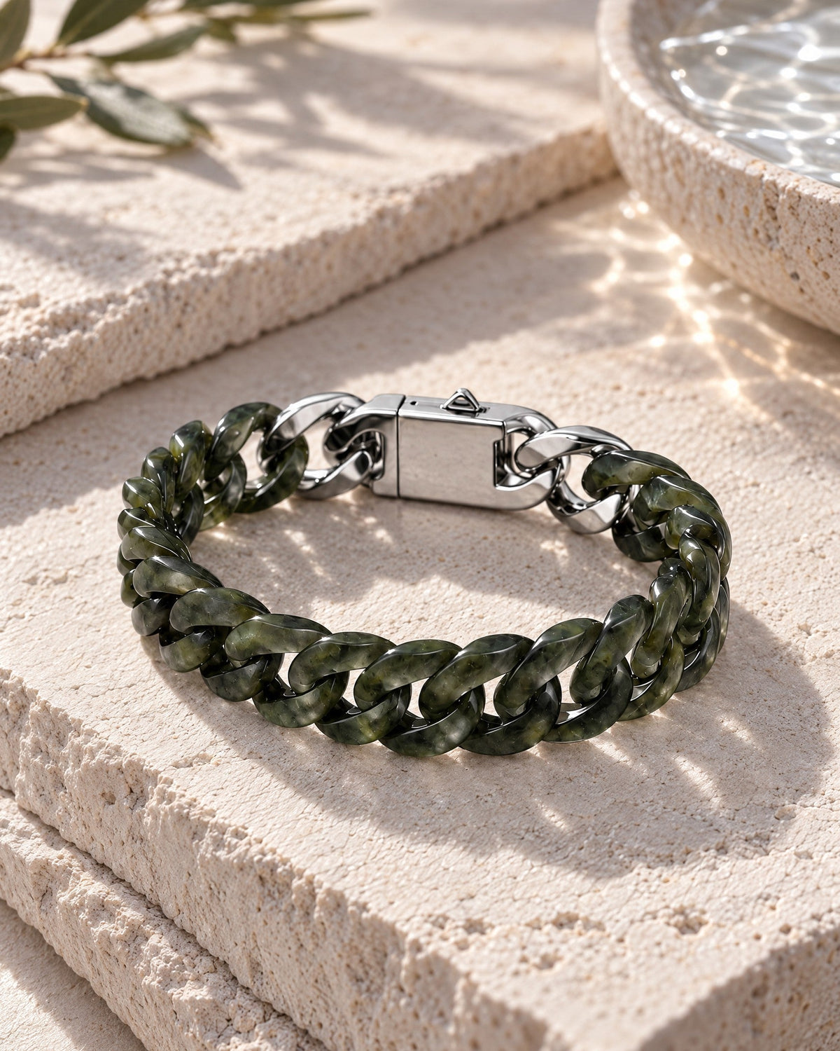 Classic Cuban Link Chain Bracelet In Light Green Nephrite resting on its side on pale stone in soft daylight