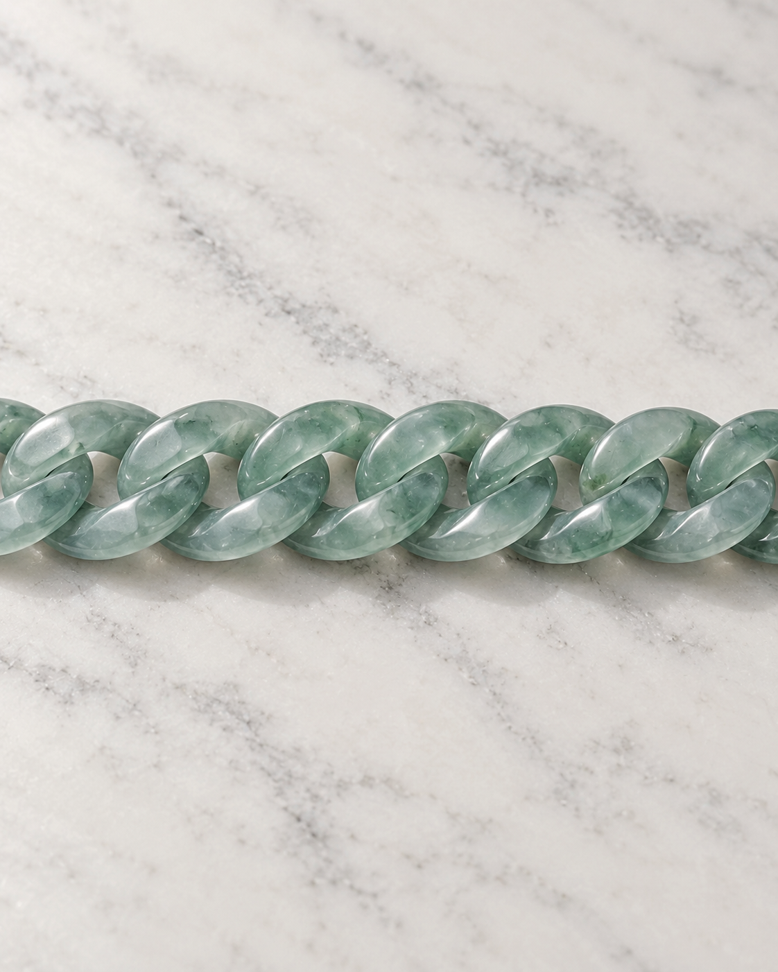 Classic Cuban Link Chain Bracelet In Top Icy Light Green Guatemalan Jade on white stone: marble tabletop detail