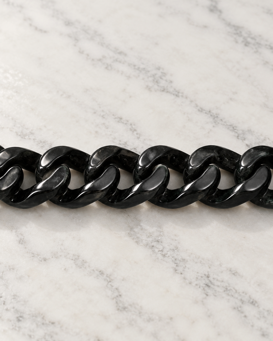 Single Piece Carved Cuban Chain Bracelet In Black Jade on white stone: marble tabletop detail