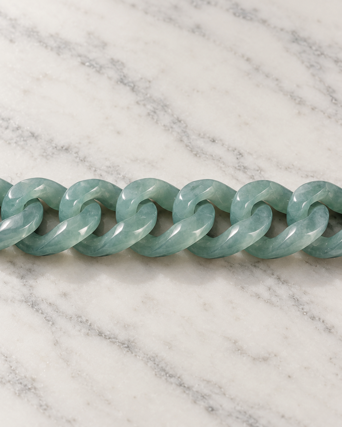 Single Piece Carved Cuban Chain Bracelet In Top Icy Green Jade on white stone: marble tabletop detail