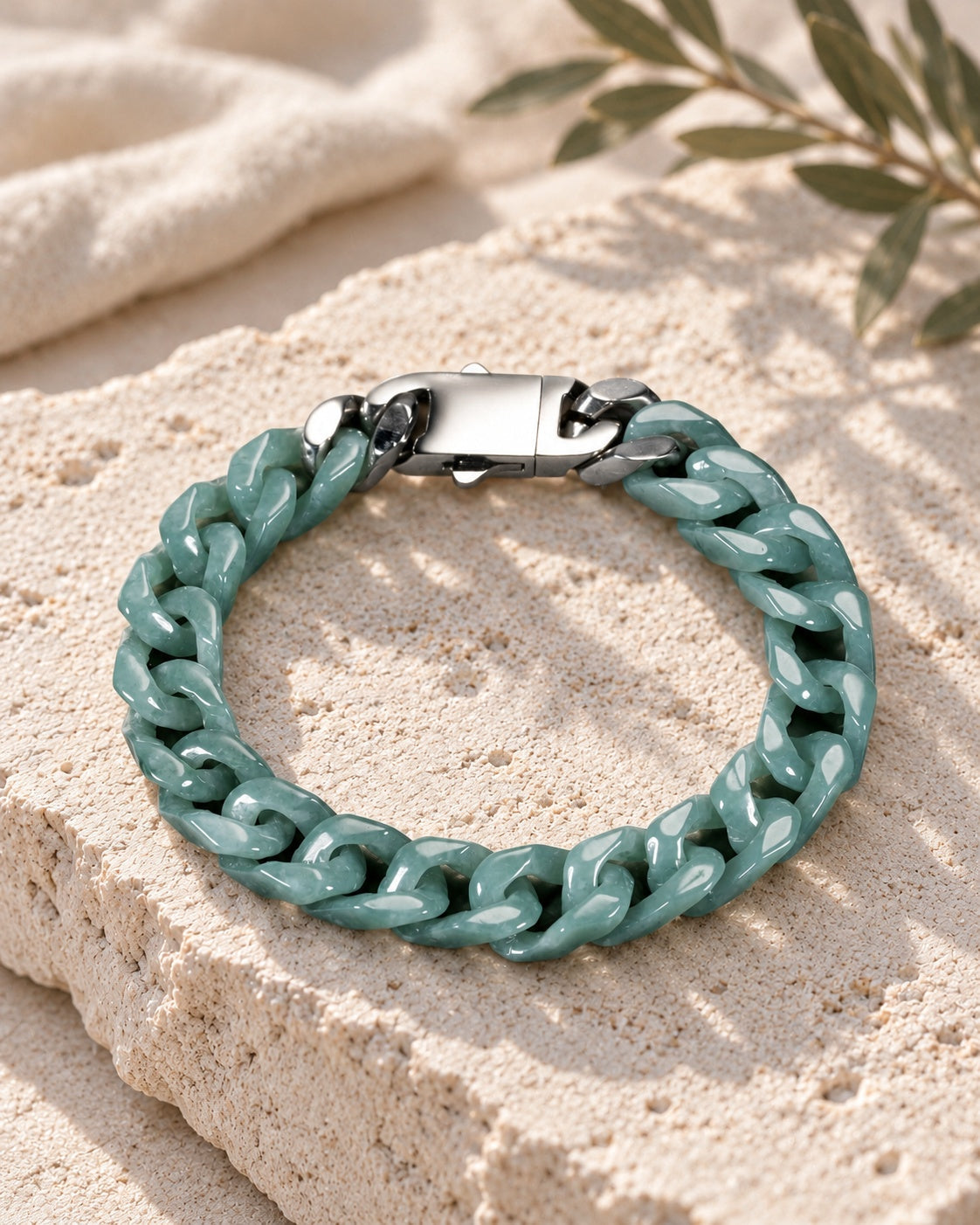 Single Piece Carved Cuban Chain Bracelet In Green Jade on white stone: Angled limestone slab
