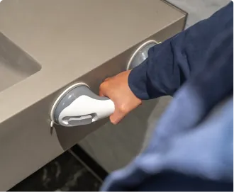 A hand steadying on the grab bar by the bathroom counter
