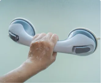 A wet hand gripping the grab bar in a shower